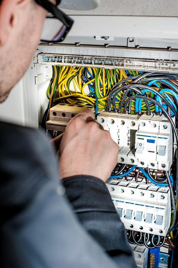 Een professionele elektricien in Bussum inspecteert de elektrische bedrading en panelen van een woning